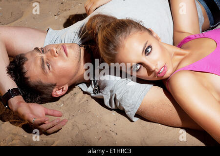 Porträt von schönen jungen Ehepaar ruht auf Sand liegend - Zufriedenheit Stockfoto
