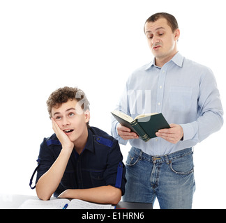 Studioaufnahme eines Teenagers sitzt an seinem Schreibtisch zeigen Langeweile, während sein Vater laut, isoliert auf weißem Hintergrund liest Stockfoto