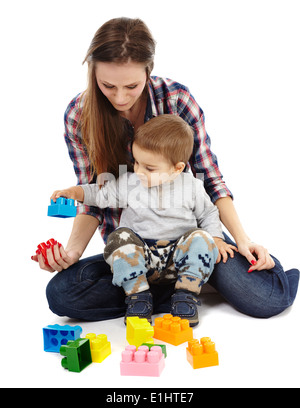 Mutter und Sohn spielt mit bunten Würfeln, am Boden Stockfoto