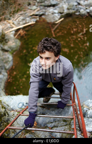 Teenager, die den Berg Kletterwand auf Sicherheit Leiter Stockfoto