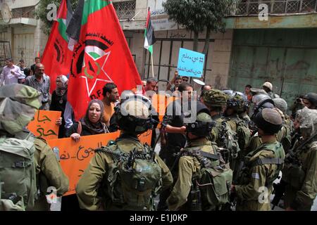 Hebron, Westjordanland, Palästinensische Gebiete. 5. Juni 2014. Palästinensische Demonstranten halten ein Schild vor israelischen Truppen während einer Protestaktion in Solidarität mit den Gefangenen in den Hungerstreik getreten, in der West Bank von Hebron 5. Juni 2014. Rund 120 Palästinenser ohne Gerichtsverfahren in Israel inhaftiert wurden auf einen unbefristeten Hungerstreik, Essen nur Salz und Wasser, seit dem 24. April, fordern ein Ende der so genannten '' Verwaltungshaft Credit: Mamoun Wazwaz/APA Images/ZUMAPRESS.com/Alamy Live News Stockfoto