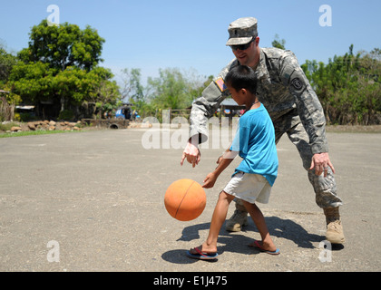US Army 1st Lt. Andrew Baughman, 6. Pionier-Bataillon, zugewiesen spielt Basketball mit einem jungen in Manggahan Dorf, Ph Stockfoto
