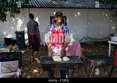 Männer machen "Roosterkoek" auf ein Feuer auf dem Blaauwklippen Wine Estate Familie Markt. Stockfoto