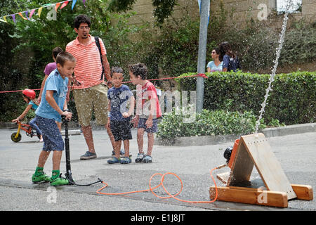 Jerusalem, Israel. 5. Juni 2014. Ein junger Besucher wird als ein unter Druck Luft Rakete hebt ab mit Wasser besprüht. Das Bloomfield Science Museum eröffnet der Jerusalem Mini Maker Faire in die "Macher" aus Israel und dem Ausland zeigen ihre Erfindungen und interaktive Workshops zu halten. Bildnachweis: Nir Alon/Alamy Live-Nachrichten Stockfoto