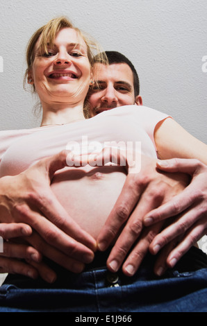 Glückliches Paar ein Kind bilden Herz mit Fingern Stockfoto