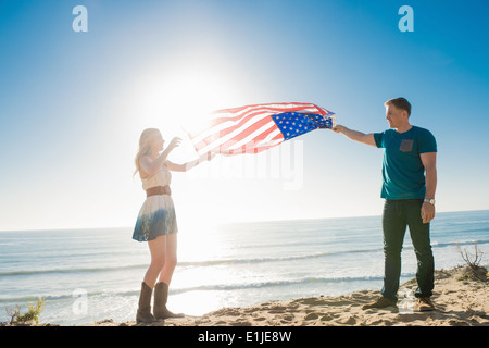 Junges Paar an Küste hält amerikanische Flagge, Torrey Pines, San Diego, Kalifornien, USA Stockfoto