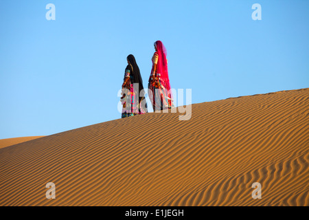 Zwei indische Frauen zu Fuß auf Dünen in der Wüste Thar, Indien Stockfoto