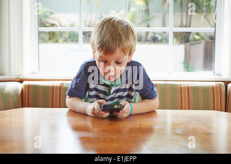 Jungen spielen handheld Videospiel Stockfoto