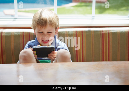 Jungen spielen handheld Videospiel Stockfoto