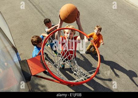 Jungen spielen Basketball, hoher Winkel Stockfoto
