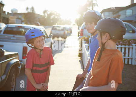 Jungen tragen Helme im Gespräch Stockfoto