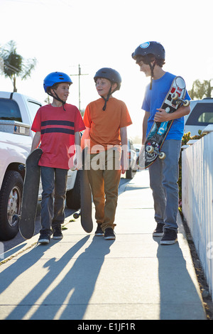 Jungen hinunter Pflaster tragen skateboards Stockfoto
