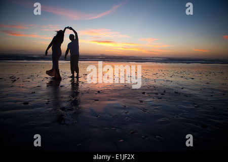 Paare tanzen am Strand bei Sonnenuntergang, Cape Town, Südafrika Stockfoto