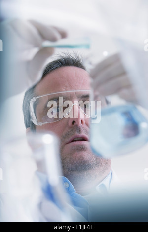 Wissenschaftler, die Flüssigkeit in Messung Becherglas gießen Stockfoto