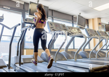 Mitte Erwachsene Frau auf Laufband im Fitnessstudio Stockfoto