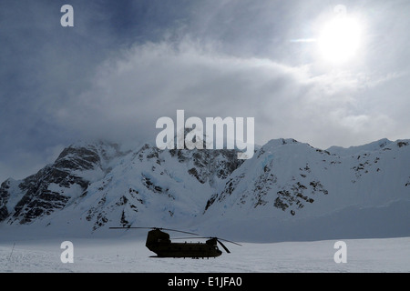 Ein US Army CH-47F Chinook-Hubschrauber betrieben durch das 1. Bataillon, 52. Aviation Regiment ist in der Sonne in der Nähe von Silhouette. Stockfoto