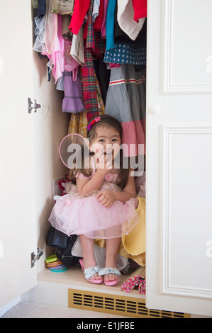 Mädchen in Prinzessin Kostüm im Schrank versteckt Stockfoto