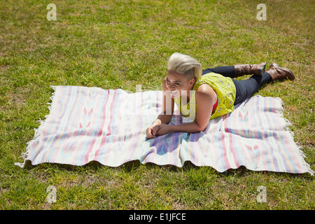 Junge Frau auf Teppich Park Gras liegend Stockfoto