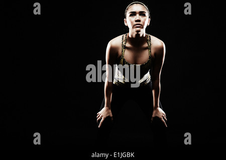 Junge Frau, die Biegung nach vorne, Hände auf die Knie Stockfoto