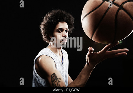 Basketball-Spieler Basketball am Finger zu balancieren Stockfoto