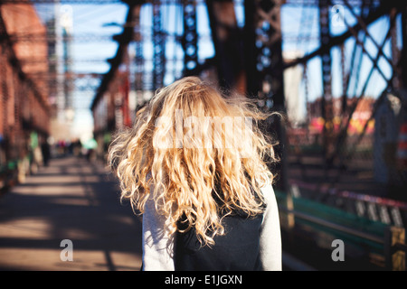 Junge Frau, die zu Fuß über die Brücke Stockfoto