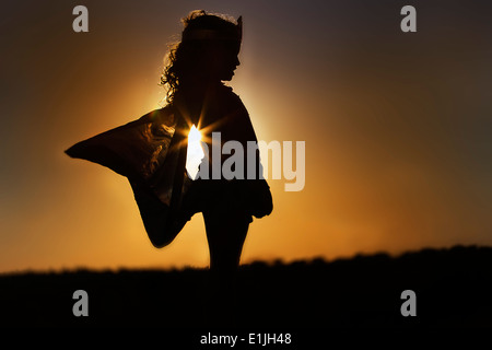 Silhouette eines jungen Mädchens in the Fairy Kostüm bei Sonnenuntergang Stockfoto