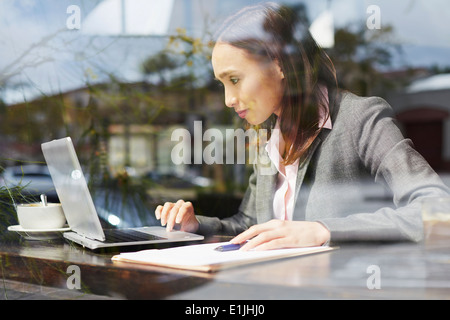 Junge weibliche Unternehmerin mit Laptop im café Stockfoto