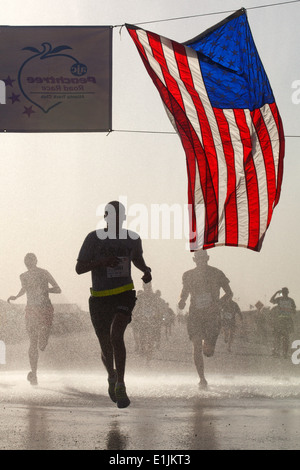 Ein US-Soldat überquert die Ziellinie in einer Sat-Version von der Atlanta Journal-Constitution Peachtree Road Race Juli Stockfoto
