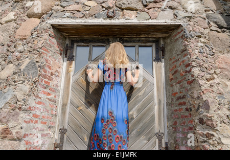 Rückansicht des Frau mit blauen Kleid am alten alten Herrenhaus Tür Eingang Stockfoto