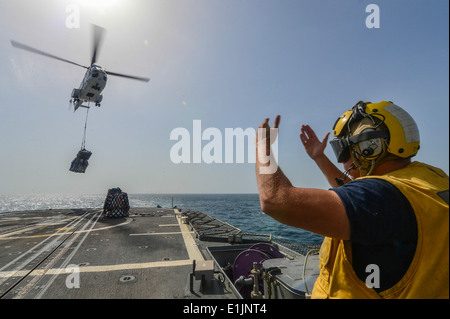 US Marine Bootsmann Mate 2. Klasse Rick Zuccaros Signale Military Sealift Command SA-330J Puma Helikopter um Fracht t liefern Stockfoto