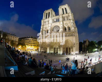 Touristen besuchen die Kathedrale Notre Dame in Paris in den späten Abend. Stockfoto