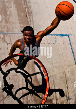 US Air Force Senior Airman Nathaniel Mills, 99. Sicherheit Kräfte Squadron Streifenpolizist einen Basketball dunks 18. September 2013, bei einer Stockfoto