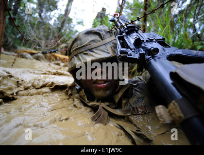 US Navy Bau Elektriker 2. Klasse Dwayne Watson nutzt seine Waffe, sein Gesicht während einer Endu Stacheldraht wegzuschieben Stockfoto