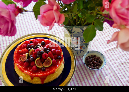 Eine köstliche Hause gebackenen Käsekuchen garniert mit verschiedenen Beeren und Feigen geschnitten. Stockfoto
