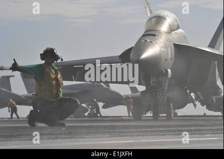 US Marine Aviation Boatswain Mate (Ausrüstung) 2. Klasse Antonio Cervantes signalisiert eine F/A-18E Super Hornet Flugzeuge starten Stockfoto