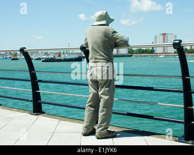 Ein Senior Herr schaut über dem Hafen von Portsmouth nach Gosport aus Gunwharf Quays Stockfoto