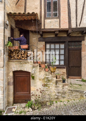 Postzustellung. Ein Zusteller legt e-Mails in einem Postfach eines restaurierten Hauses in Cordes. Cordes Sur Ciel, Tarn, Frankreich Stockfoto