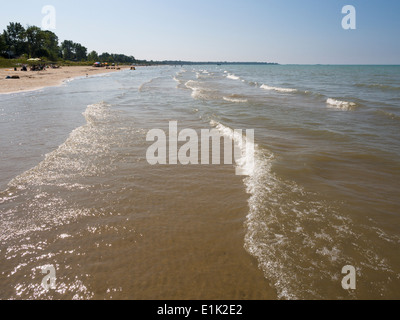 Sommer am Lake Huron Strand. Sanfte Wellen Rollen Ipperwash Strand, während Sonnenanbeter das Ufer säumen. Stockfoto