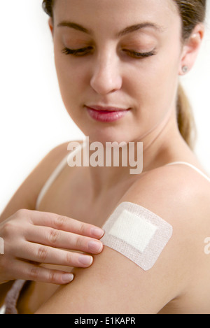 MODEL Release Teenage Mädchen mit einem Wundpflaster auf dem Arm. Stockfoto