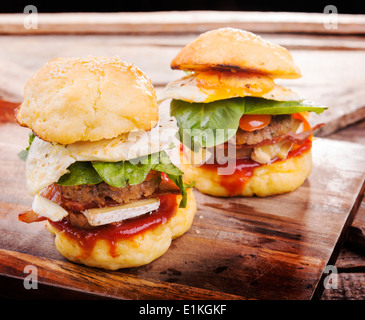 Hausgemachte glutenfreie Mini-Burger oder Schieber mit Rindfleisch, Ei, Salat, Käse und Soße Stockfoto