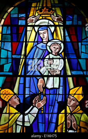 Glasmalerei Darstellung eine gekrönte Jungfrau mit Kind geben einen Rosenkranz, einem Bischof Stockfoto