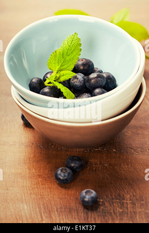 frische Beeren in einer Schüssel auf hölzernen Hintergrund Stockfoto