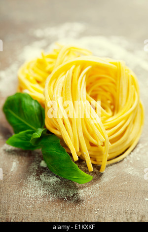 Frische Pasta und Basilikum auf Holztisch Stockfoto