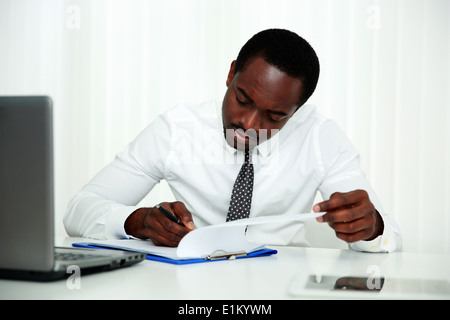 Afrikanischer Mann unterschreiben im Büro Stockfoto