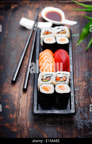 Sushi mit Stäbchen auf hölzernen Hintergrund Stockfoto
