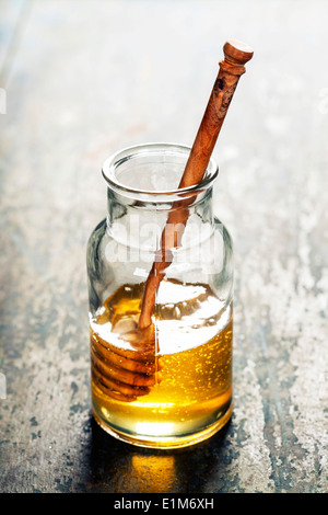Glasglas Honig mit hölzernen drizzler Stockfoto