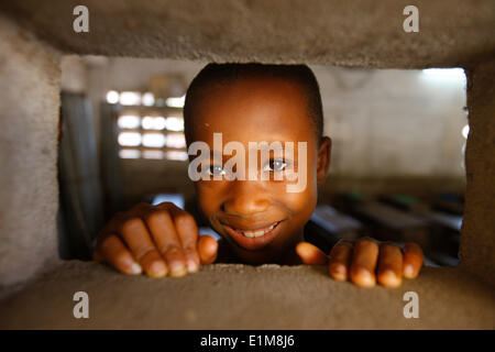 Afrikanischen jungen Blick durch eine Öffnung Stockfoto