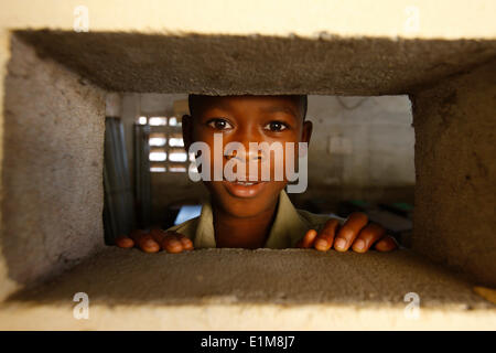 Afrikanischen jungen Blick durch eine Öffnung Stockfoto
