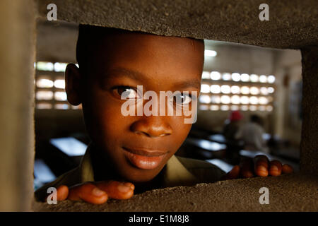 Afrikanischen jungen Blick durch eine Öffnung Stockfoto