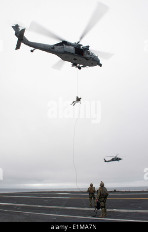 US-Segler mit Explosive Ordnance Mobile Abfallbehälter 3 Abseilen aus einem MH-60 Seahawk Hubschrauber Helikopter Meer zugewiesen Stockfoto